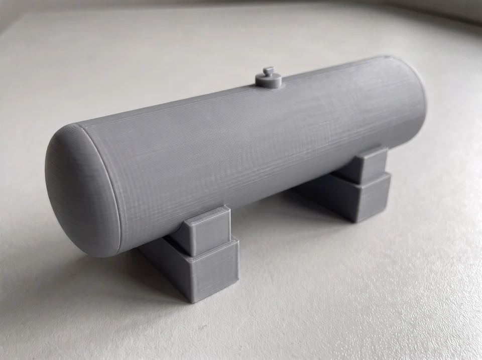 Nahansicht des grauen H₂-Tanks als PLA-Materialstudie mit feinen Schichten auf einer matten Unterlage.